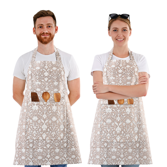 Two people wearing floral aprons with wooden utensils on a white background