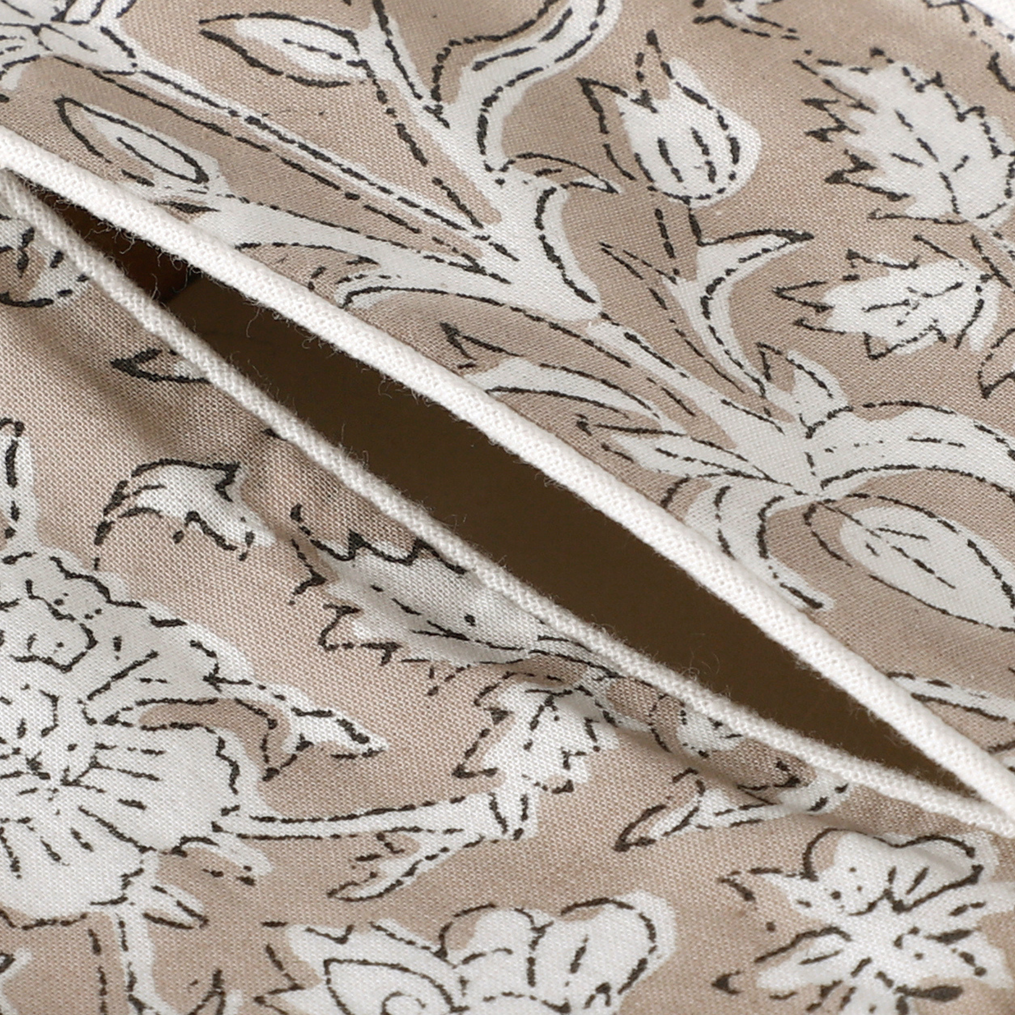 Close-up of beige fabric with black floral pattern