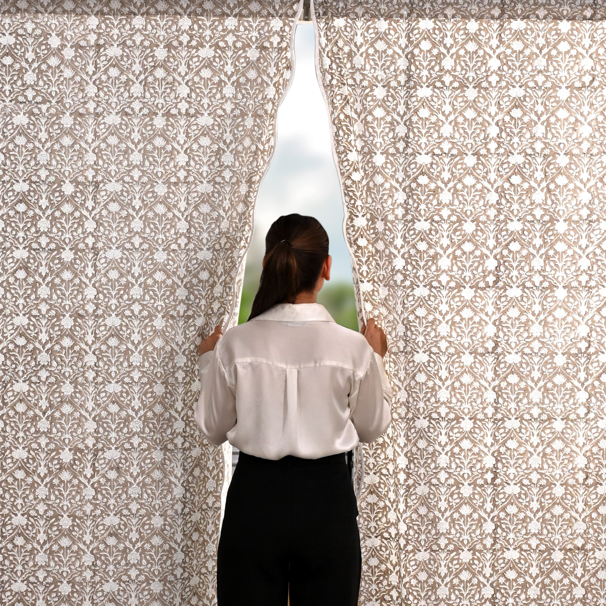 Person looking out a window with a decorative curtain