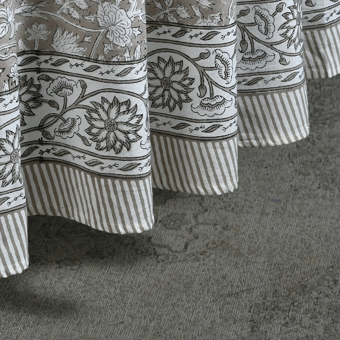 Close-up of patterned curtains on a textured surface