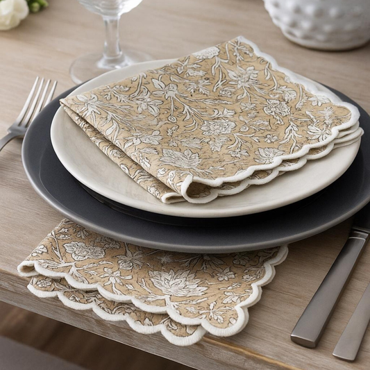 Set of plates with folded beige floral napkins on a wooden table.