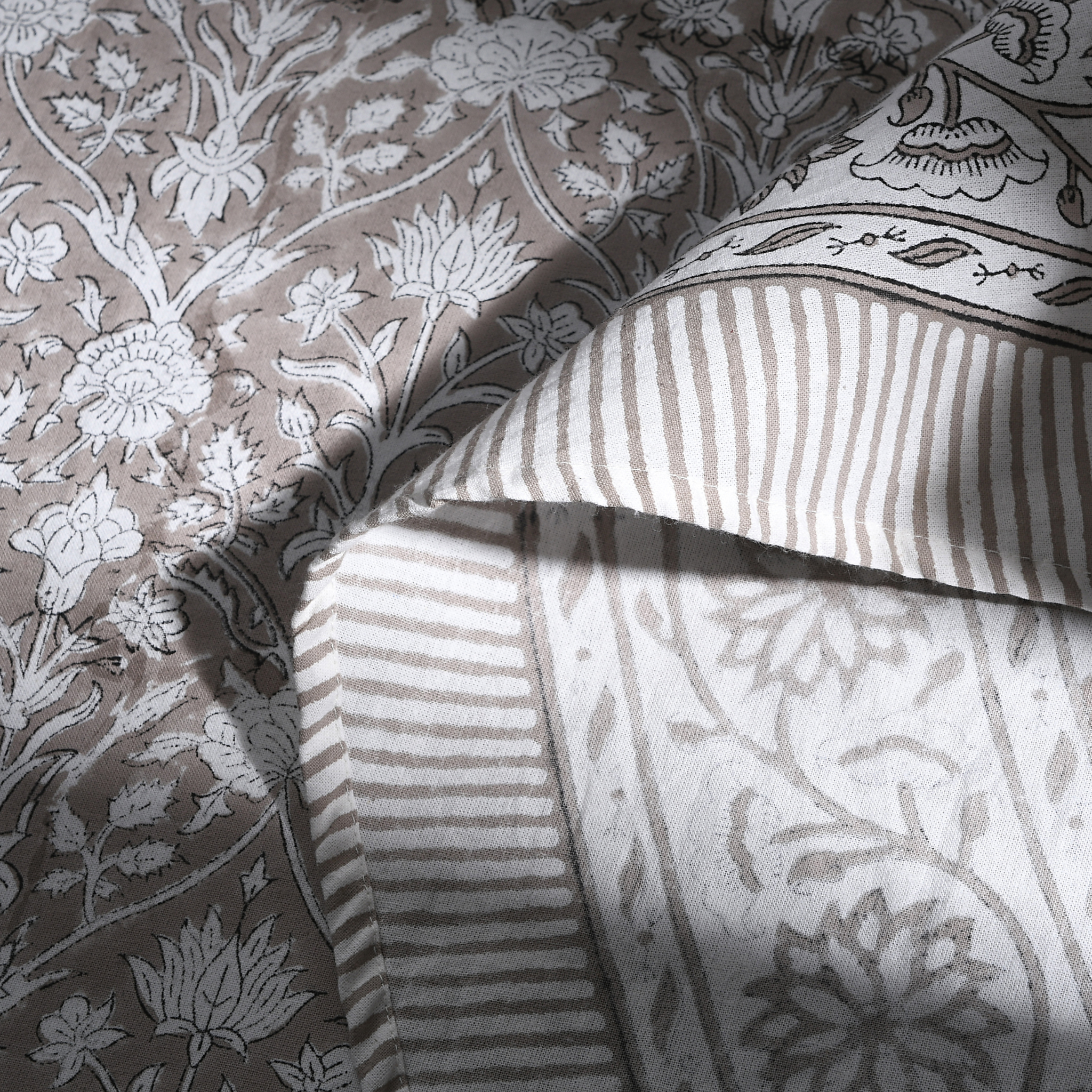 Close-up of patterned fabric with floral and striped designs.