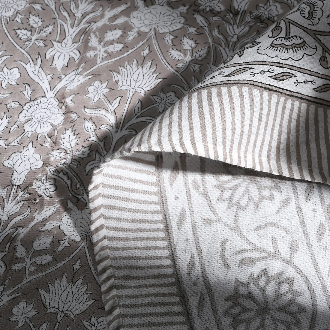 Close-up of patterned fabric with floral and striped designs.