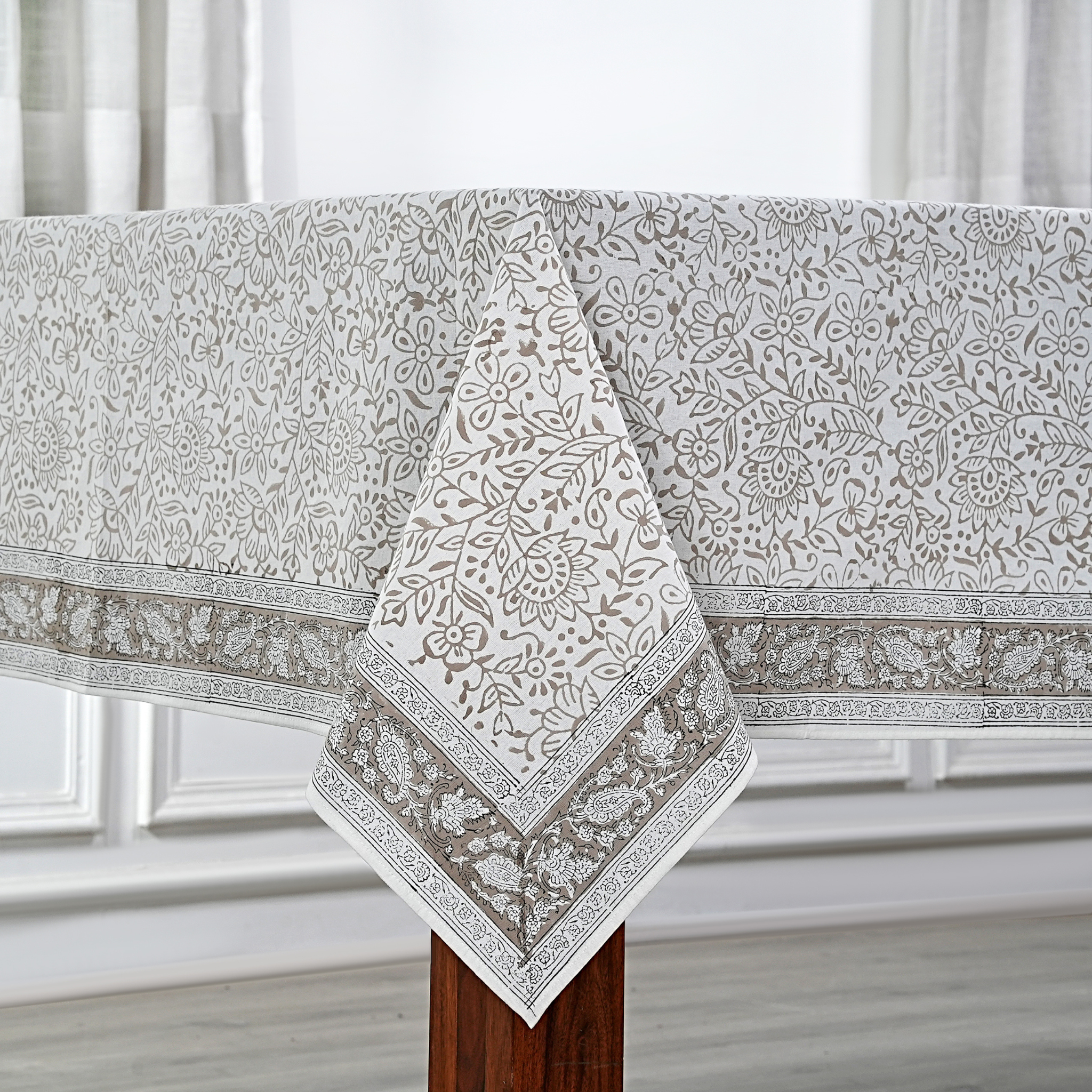 Decorative tablecloth with floral pattern on a wooden table