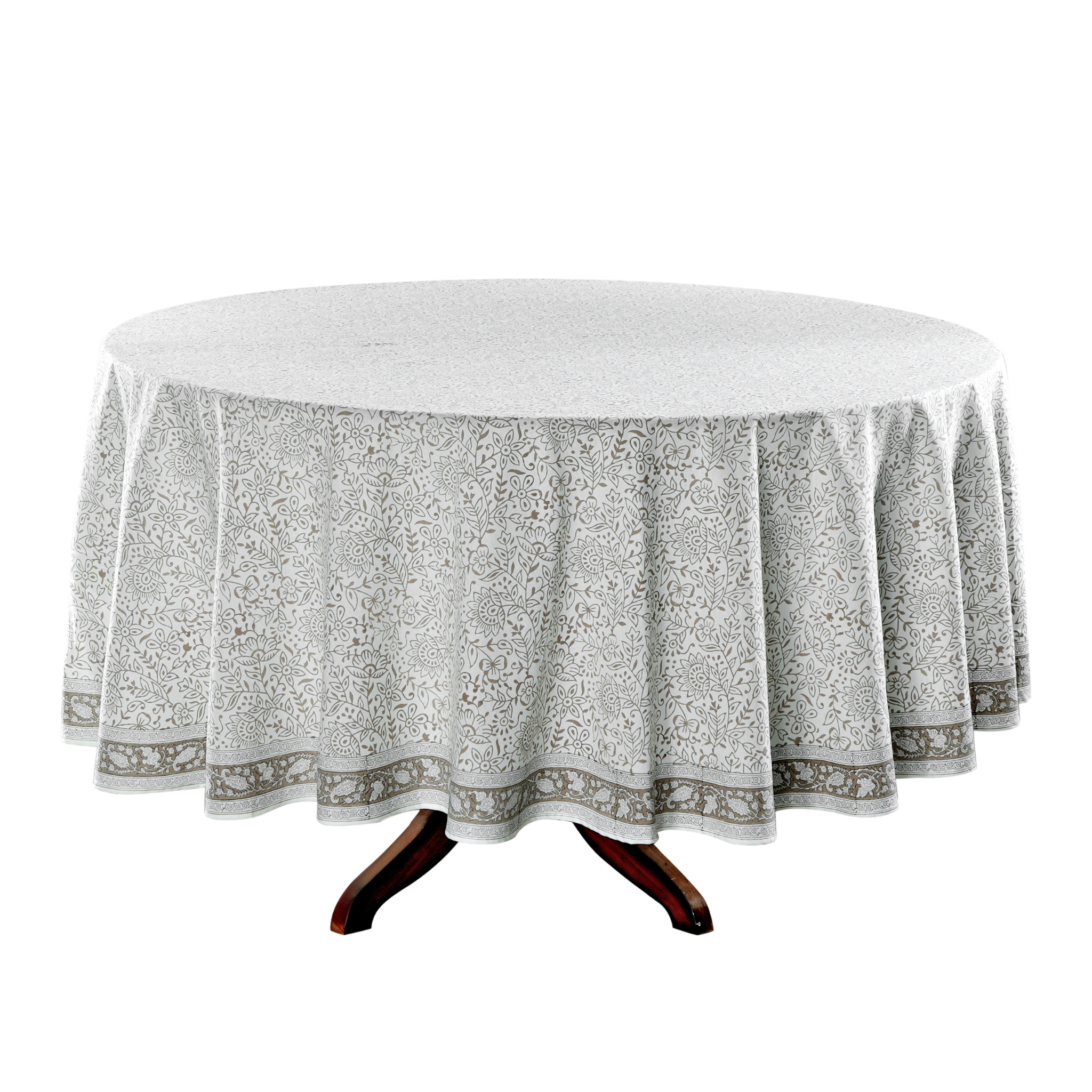 Round table with a floral patterned tablecloth on a white background