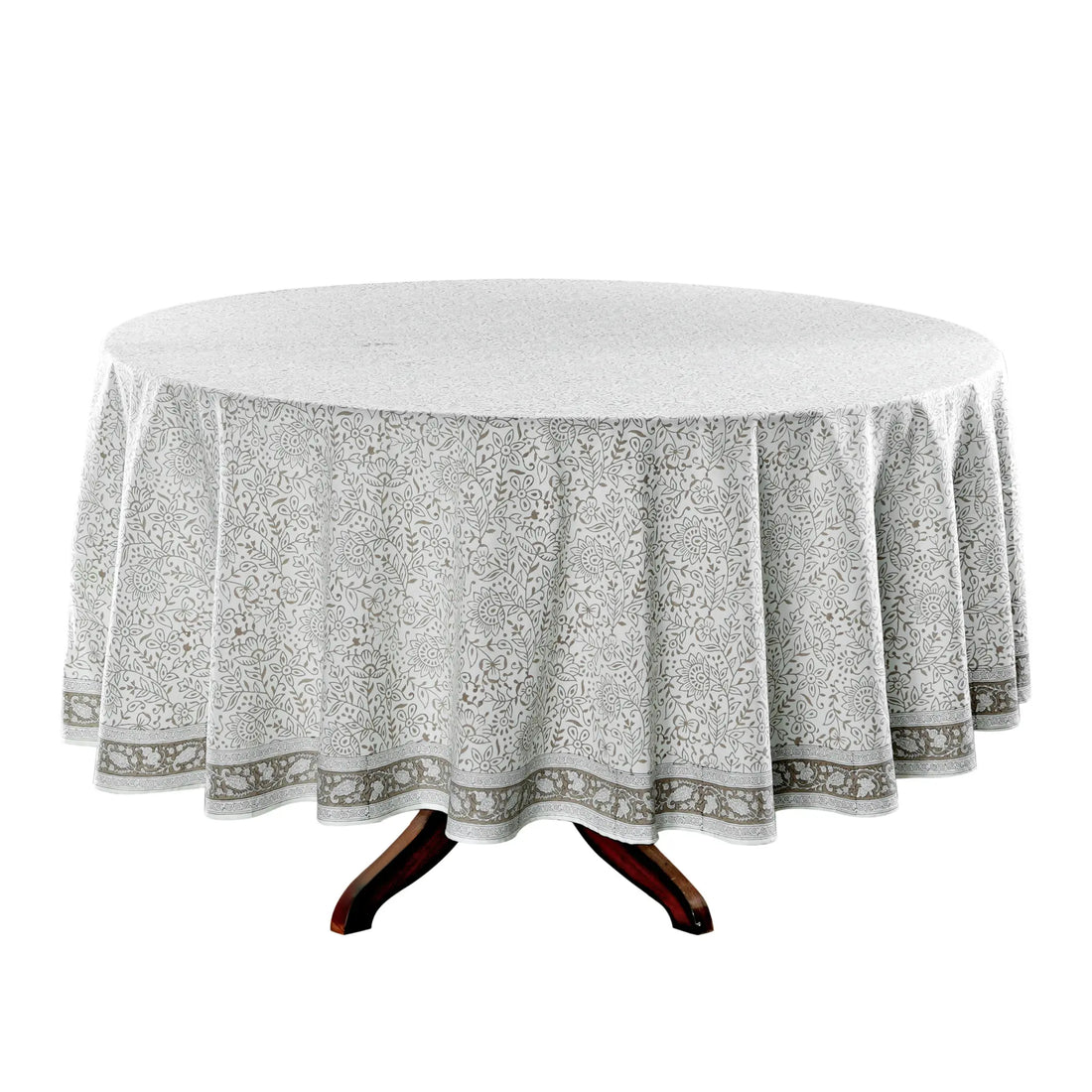 Round table with a floral patterned tablecloth on a white background