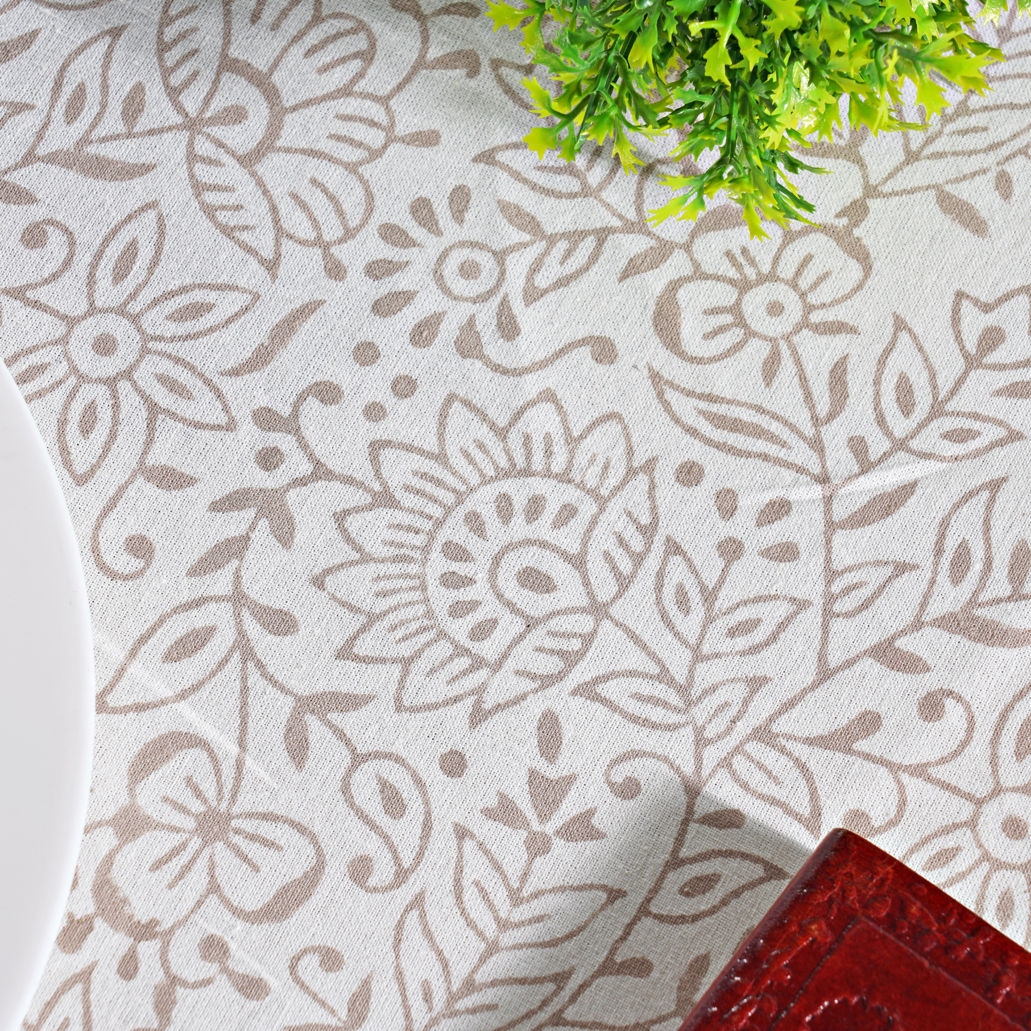 Floral patterned fabric with a plant and red object in the background