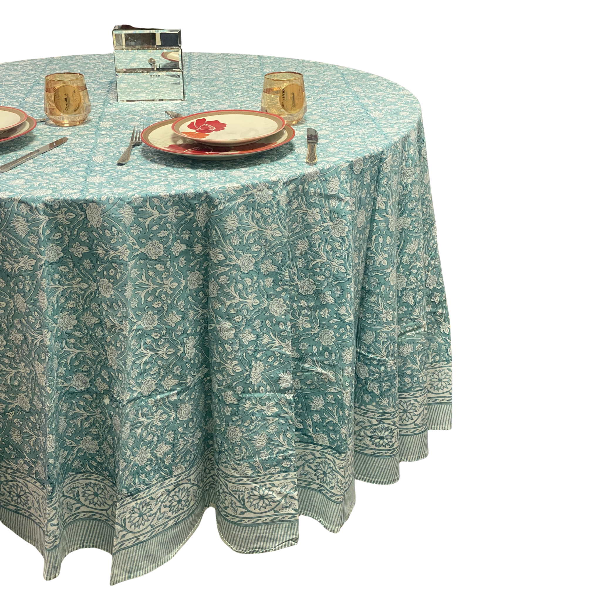 Round table with a floral patterned tablecloth on a white background