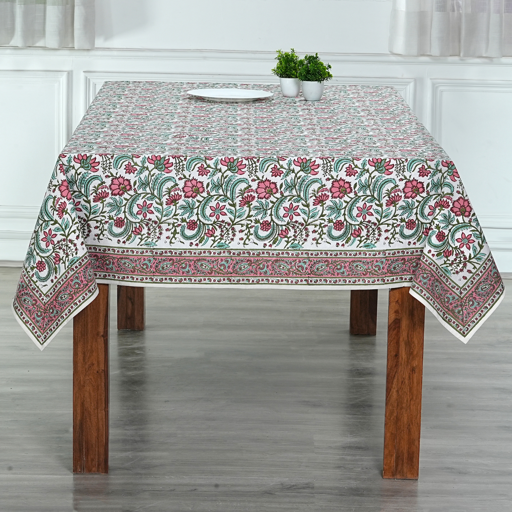 Floral patterned tablecloth on a wooden table with a neutral background