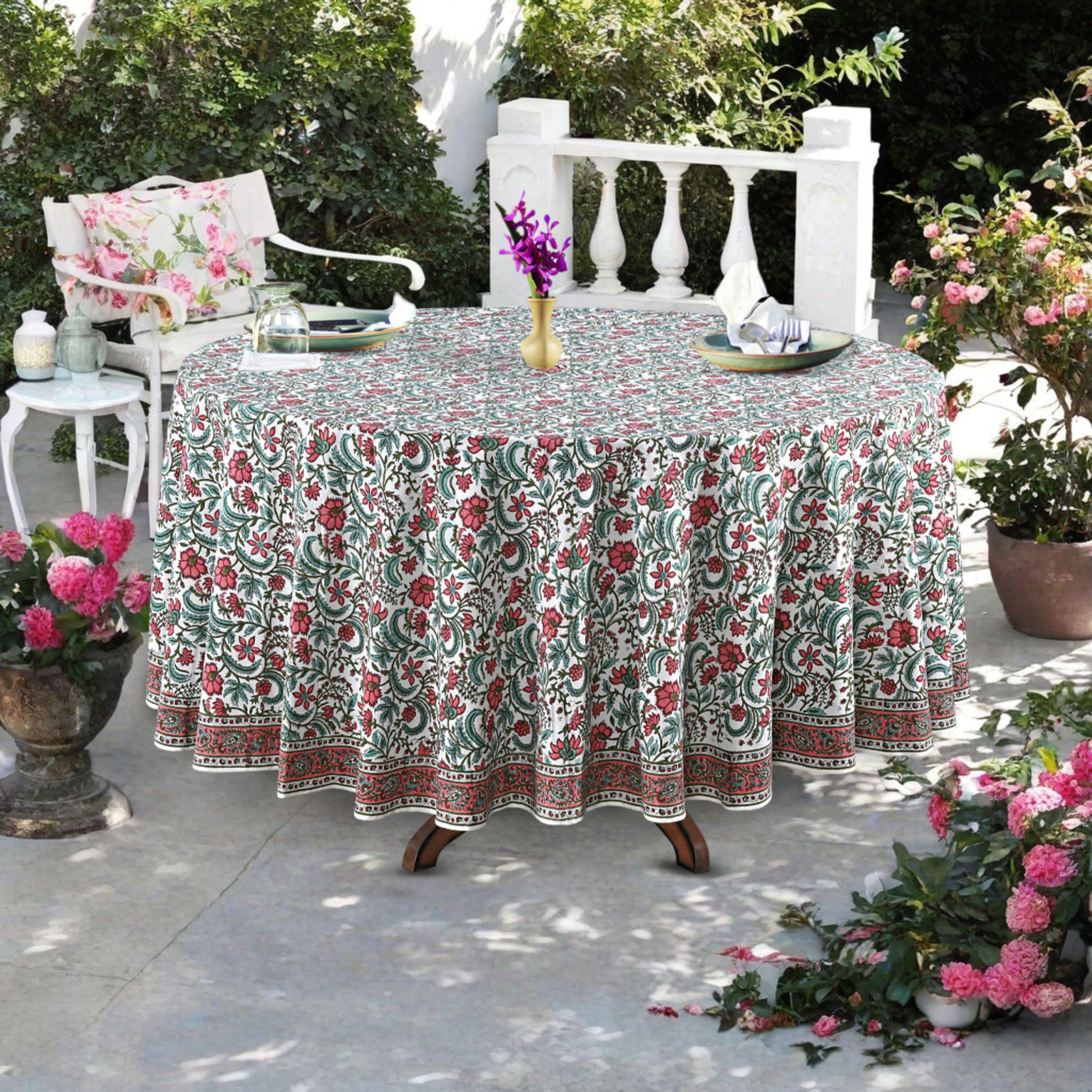 Round table with a floral tablecloth outdoors on a patio