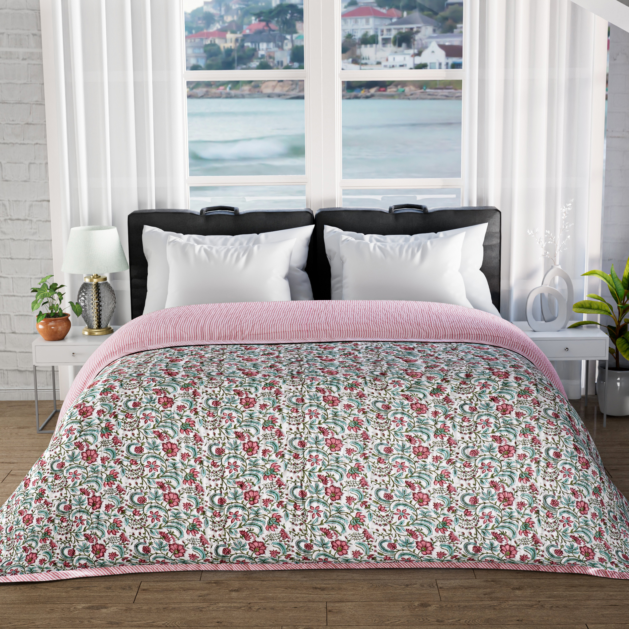 Floral quilt on a bed with a window view of water and buildings