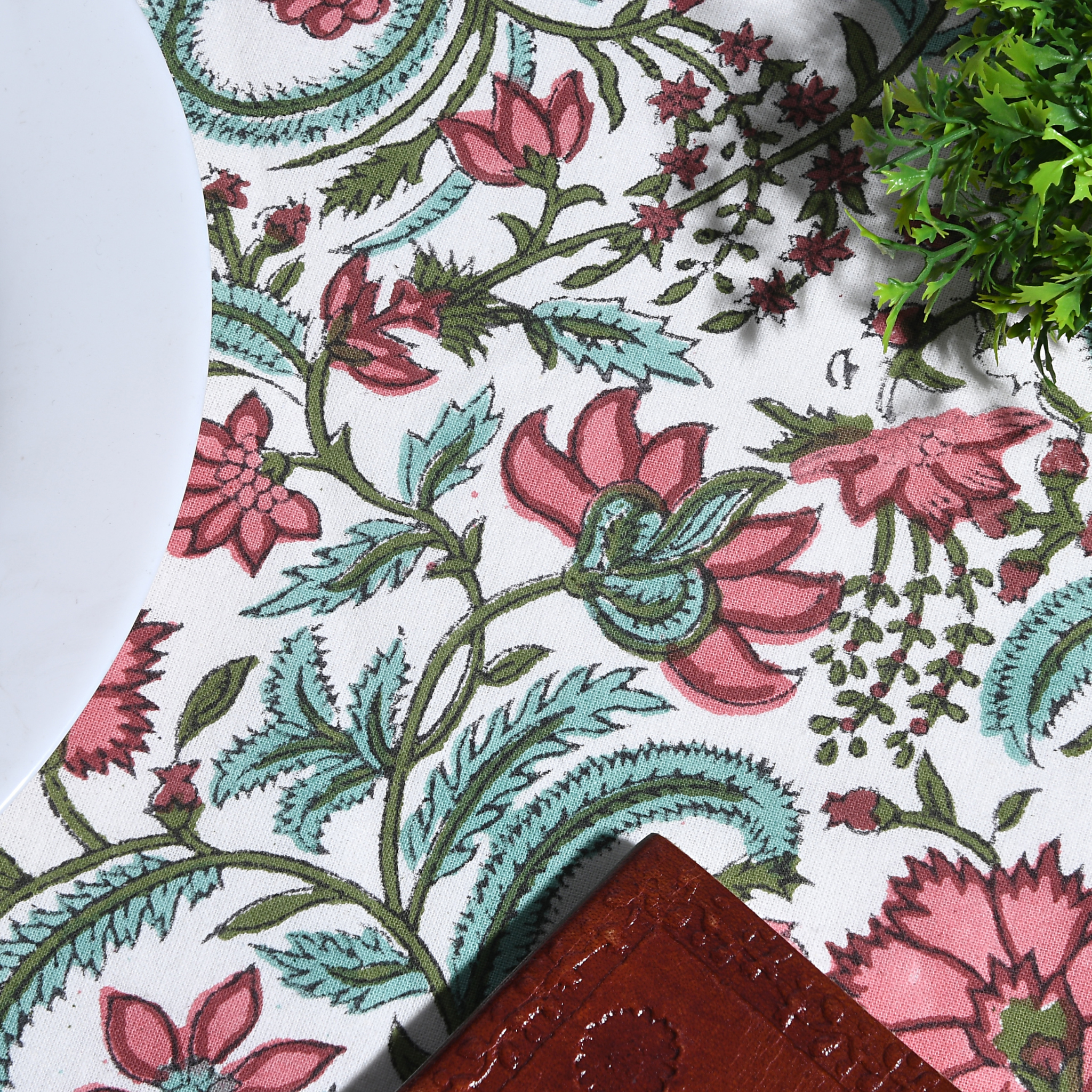 Floral patterned fabric with pink and green flowers on a white background