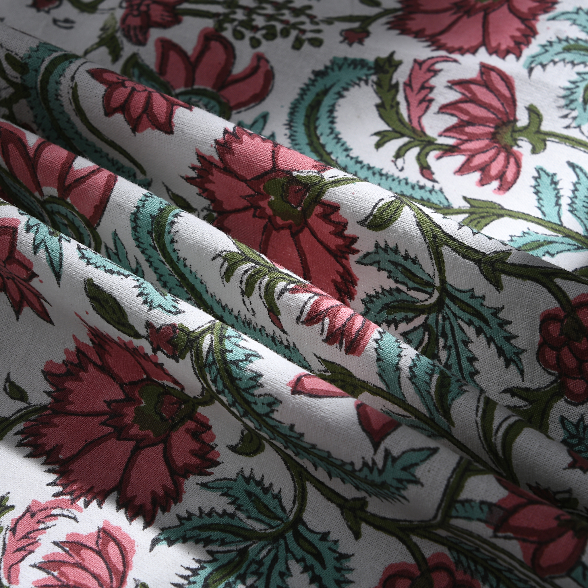 Close-up of floral fabric with pink and green flowers on a white background