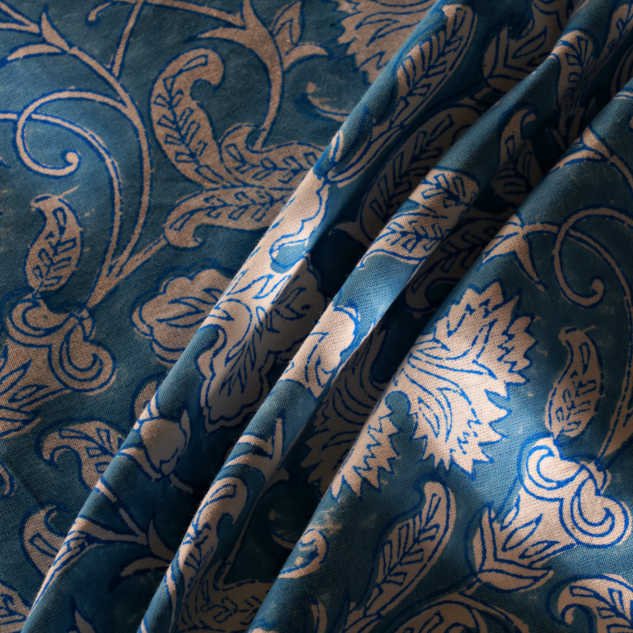 Close-up of blue fabric with intricate gold patterns