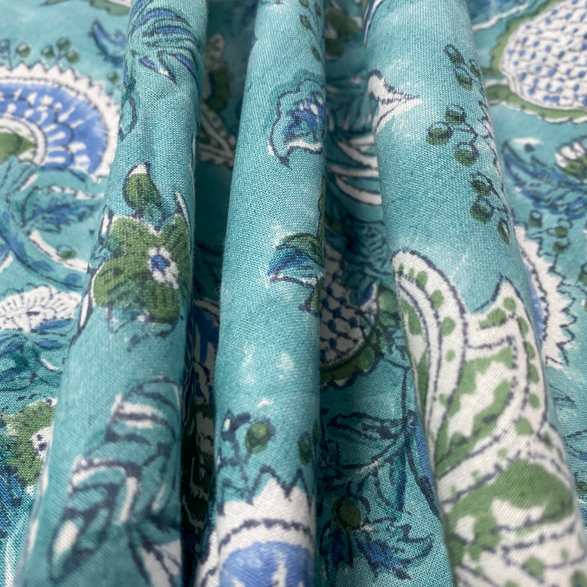 Close-up of teal fabric with intricate patterns