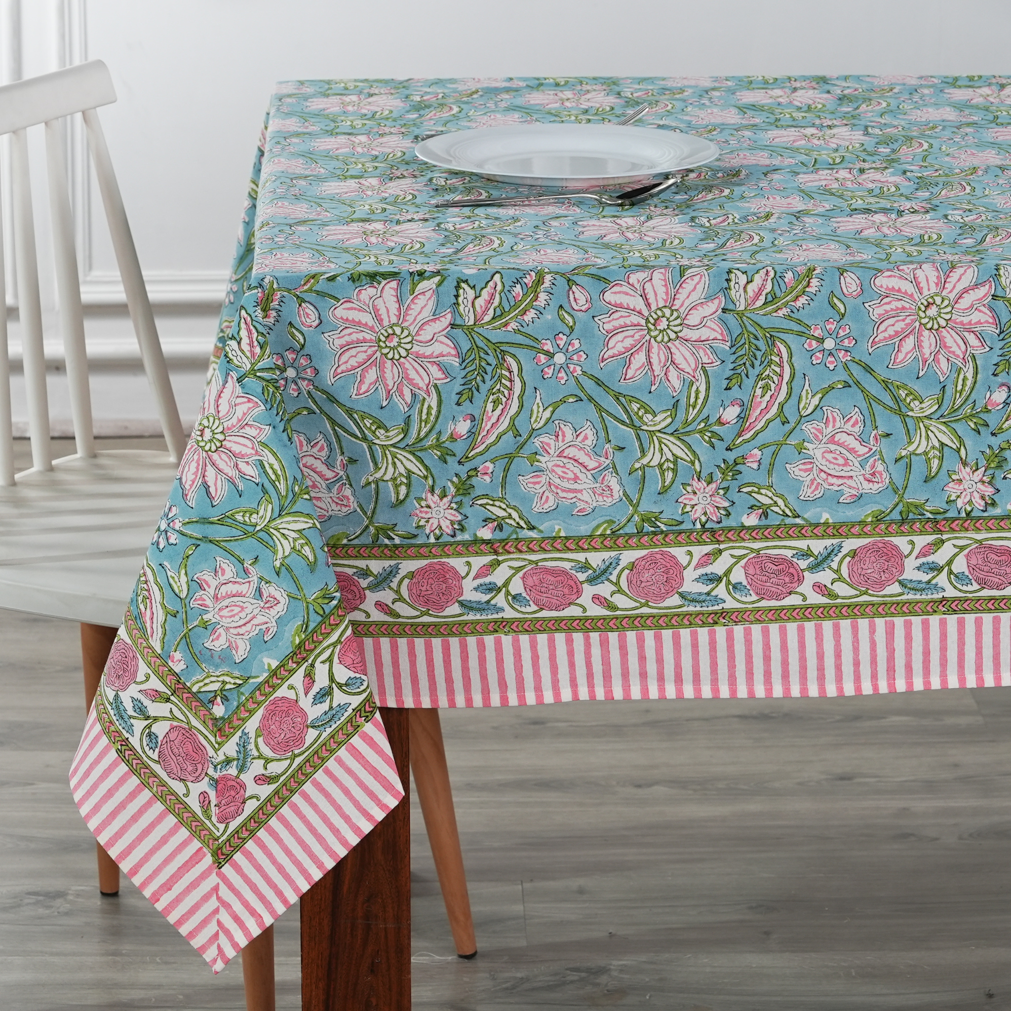 Floral patterned tablecloth on a dining table with a striped border