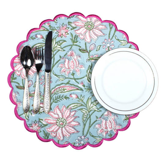 Floral-patterned placemat with cutlery and a plate on a white background