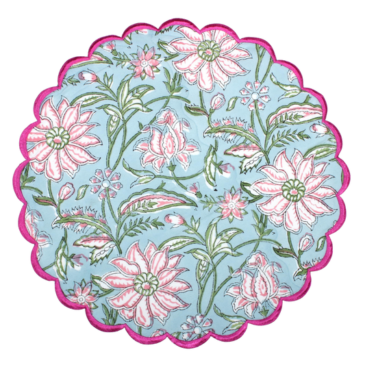 Round floral mat with pink flowers and green leaves on a light blue background