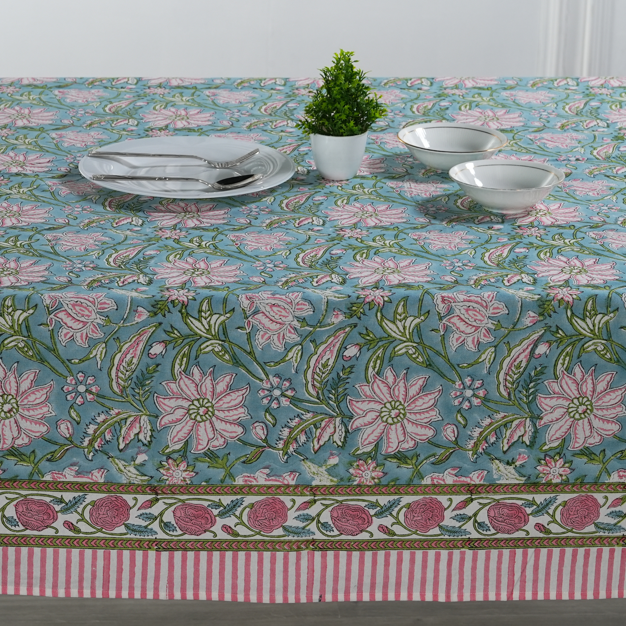 Floral patterned tablecloth with a table set on top
