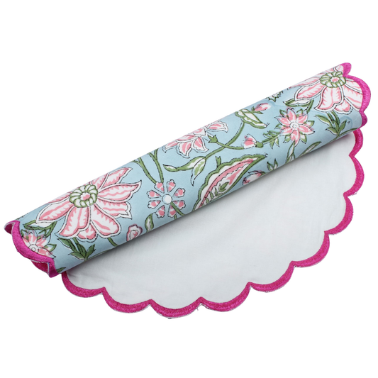 Floral-patterned mat with pink scalloped edge on a white background