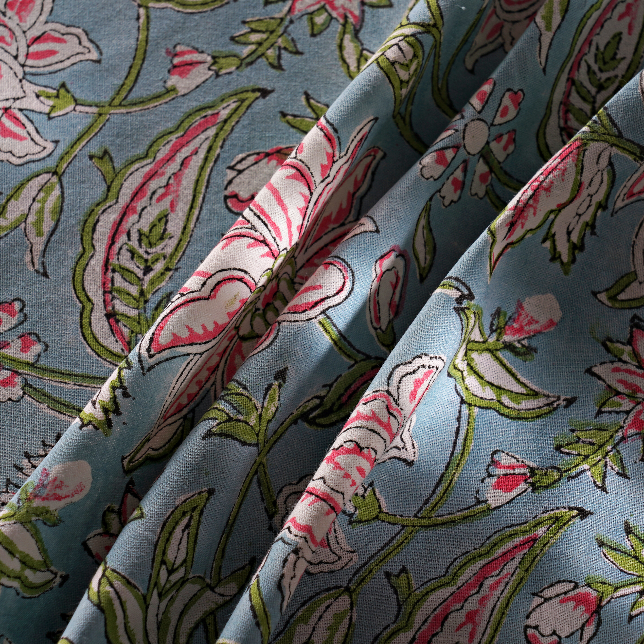 Floral fabric pattern with pink and green flowers on a blue background