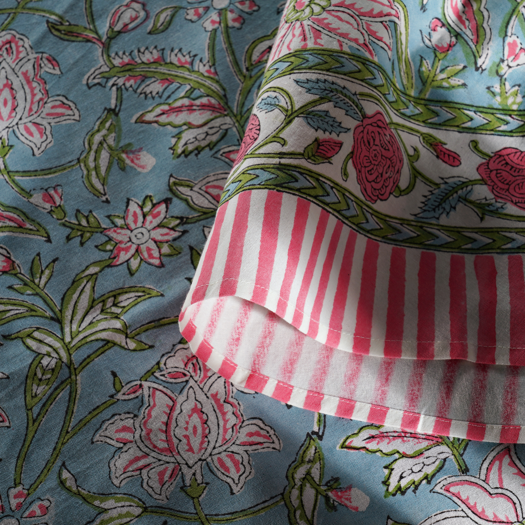 Close-up of floral fabric with pink and white striped fabric on top