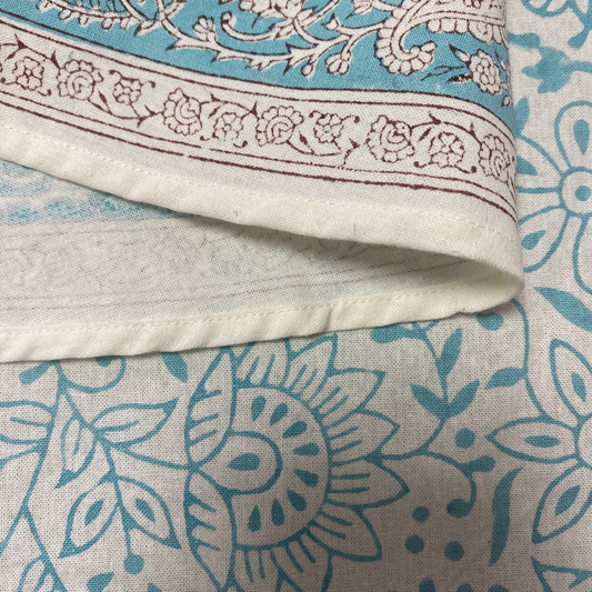 Close-up of a fabric with intricate patterns in blue and beige.