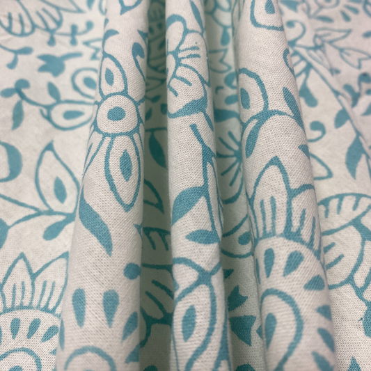 Close-up of fabric with blue floral pattern on beige background