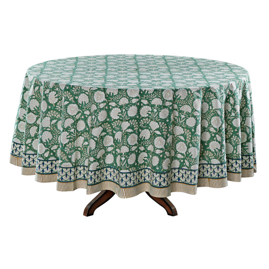 Round table with a green floral patterned tablecloth on a white background