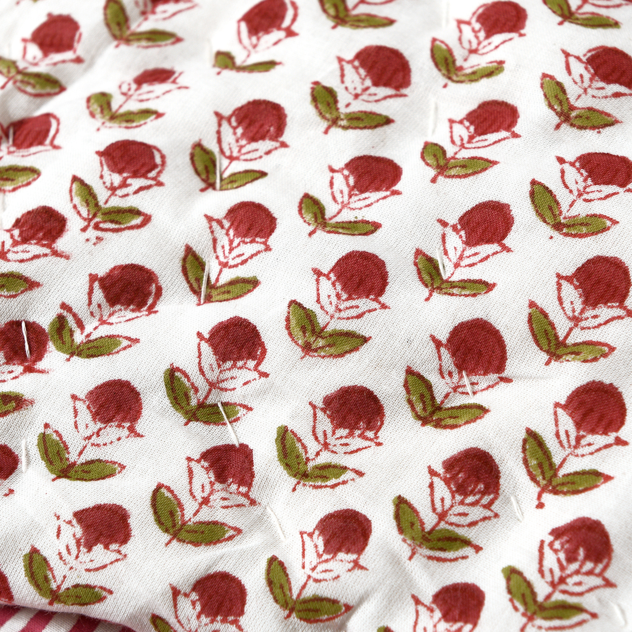Fabric with red and green floral pattern on a white background
