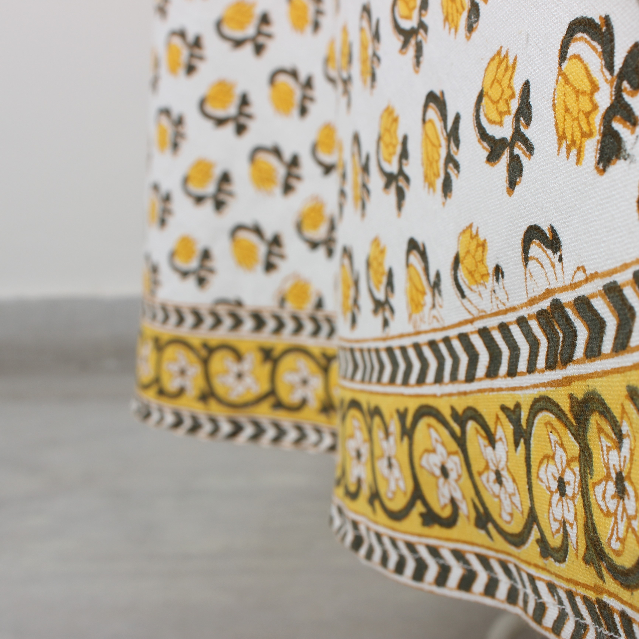 Close-up of a fabric with yellow, black, and white pattern on a neutral background