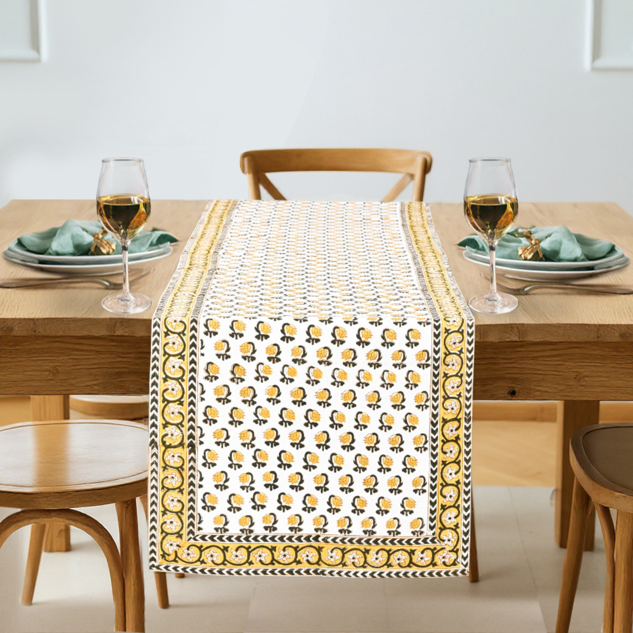 Dining table set with a decorative table runner featuring yellow floral patterns.