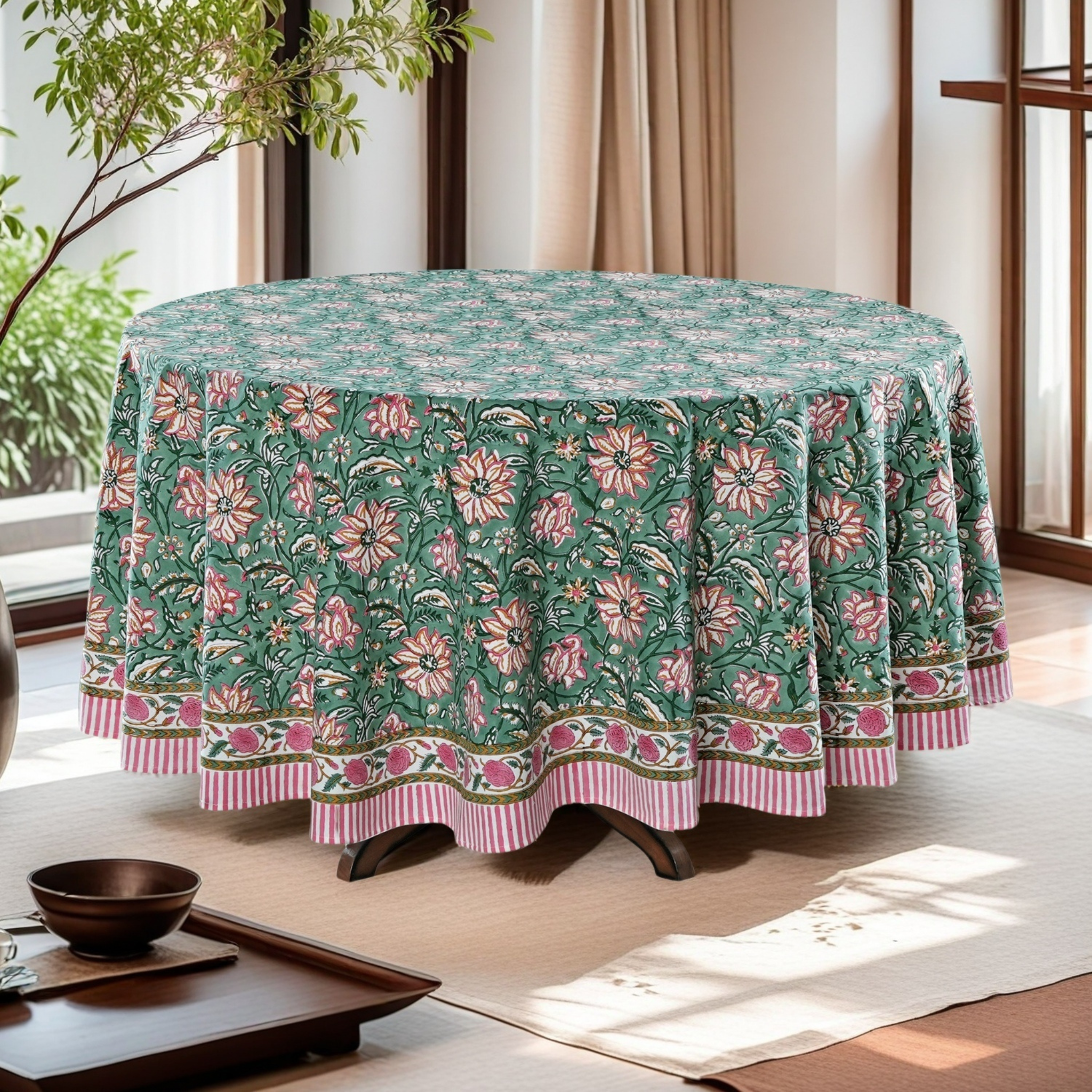 Round table with a floral patterned tablecloth in a bright room.