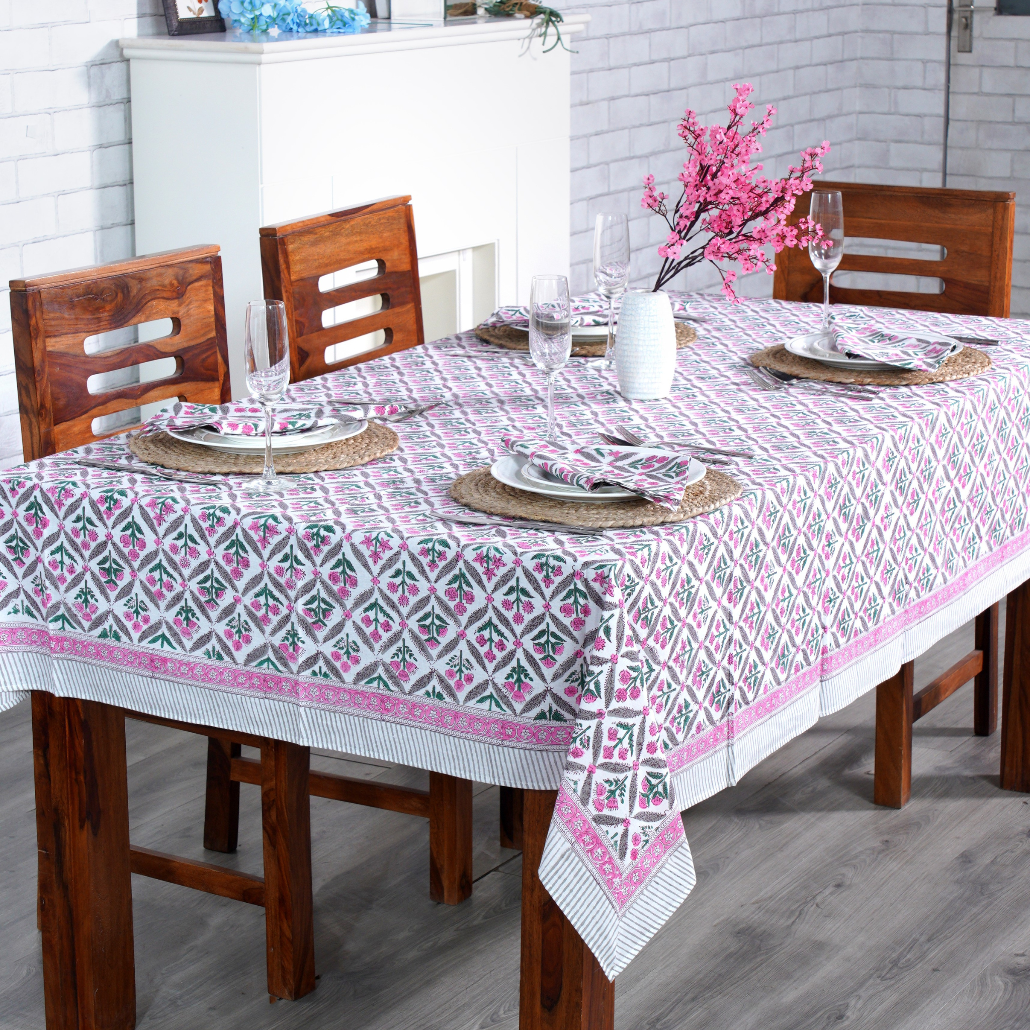 Dining table set with a patterned tablecloth, chairs, and decorative elements.