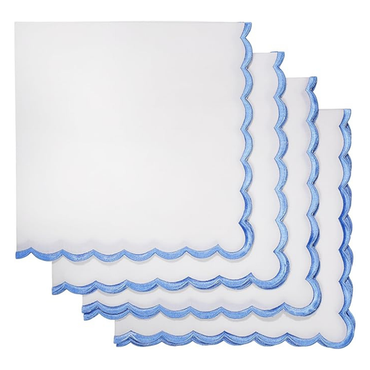Set of white napkins with blue scalloped edges on a white background
