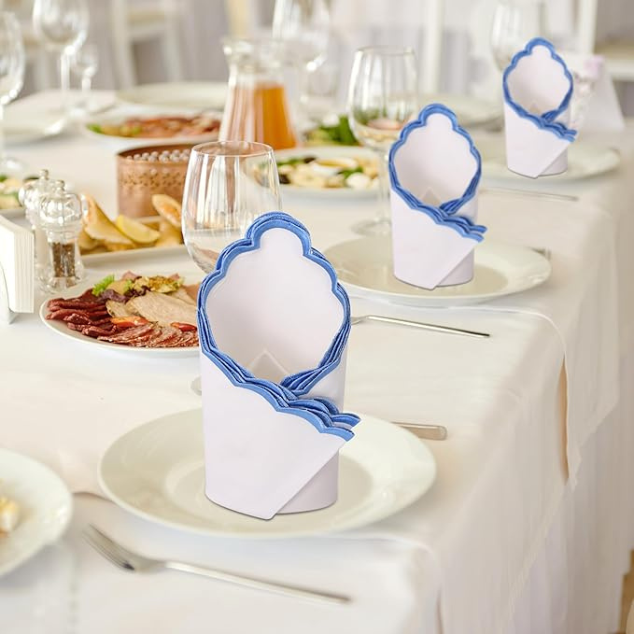 Napkin holder with blue accents on a table setting with plates and glasses.