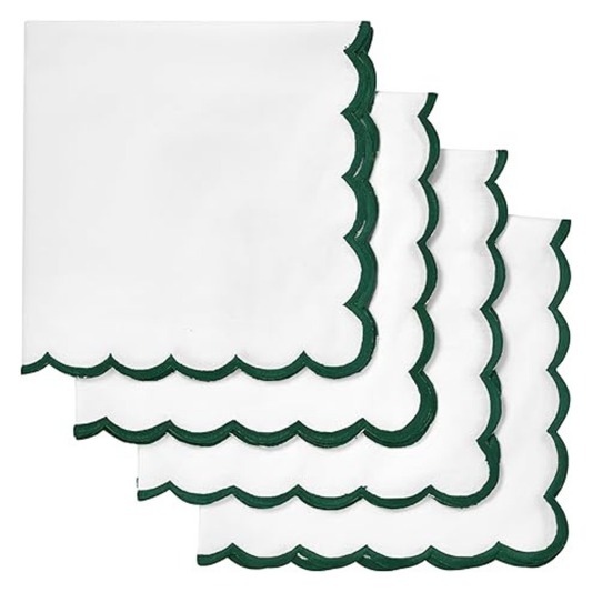 Set of white napkins with green scalloped edges on a white background