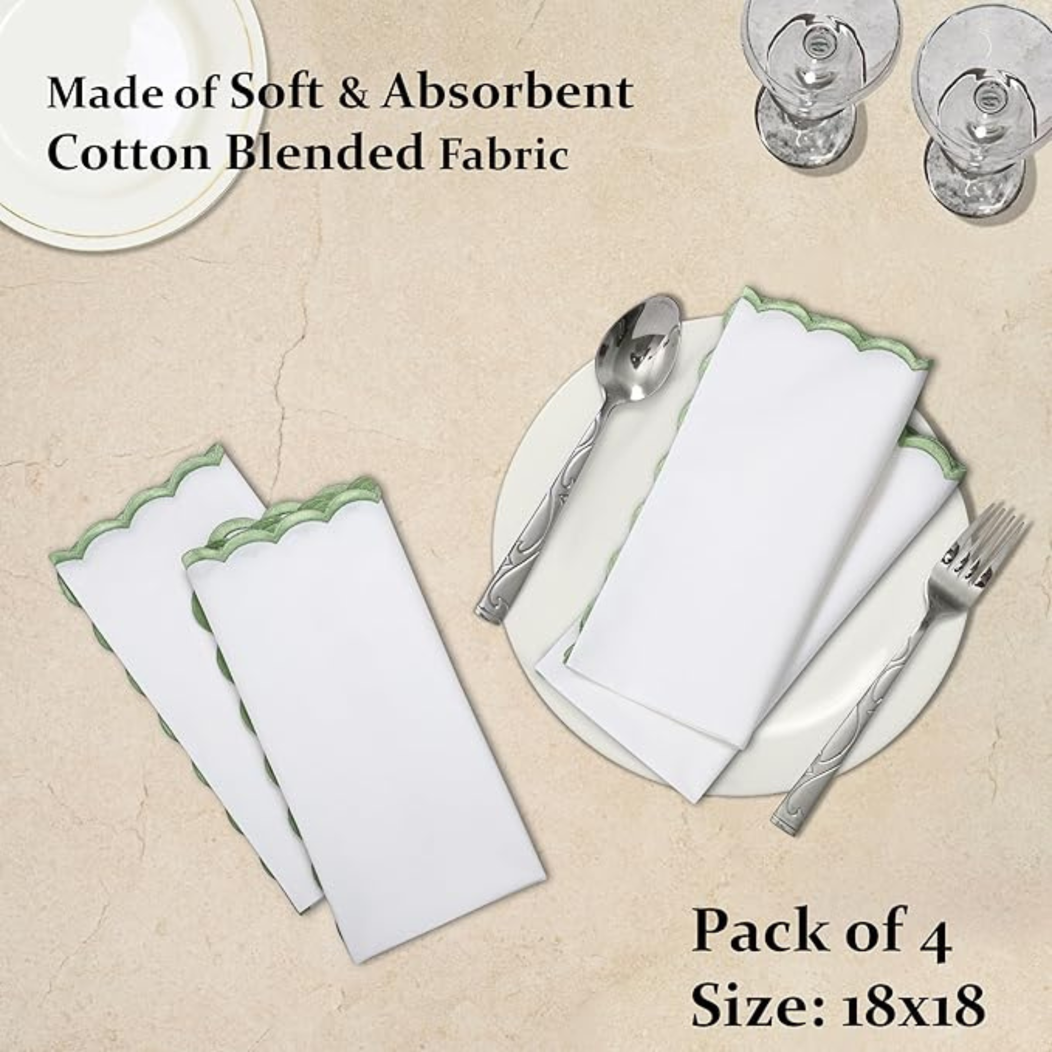 Set of white napkins with green trim on a beige surface, accompanied by silverware.