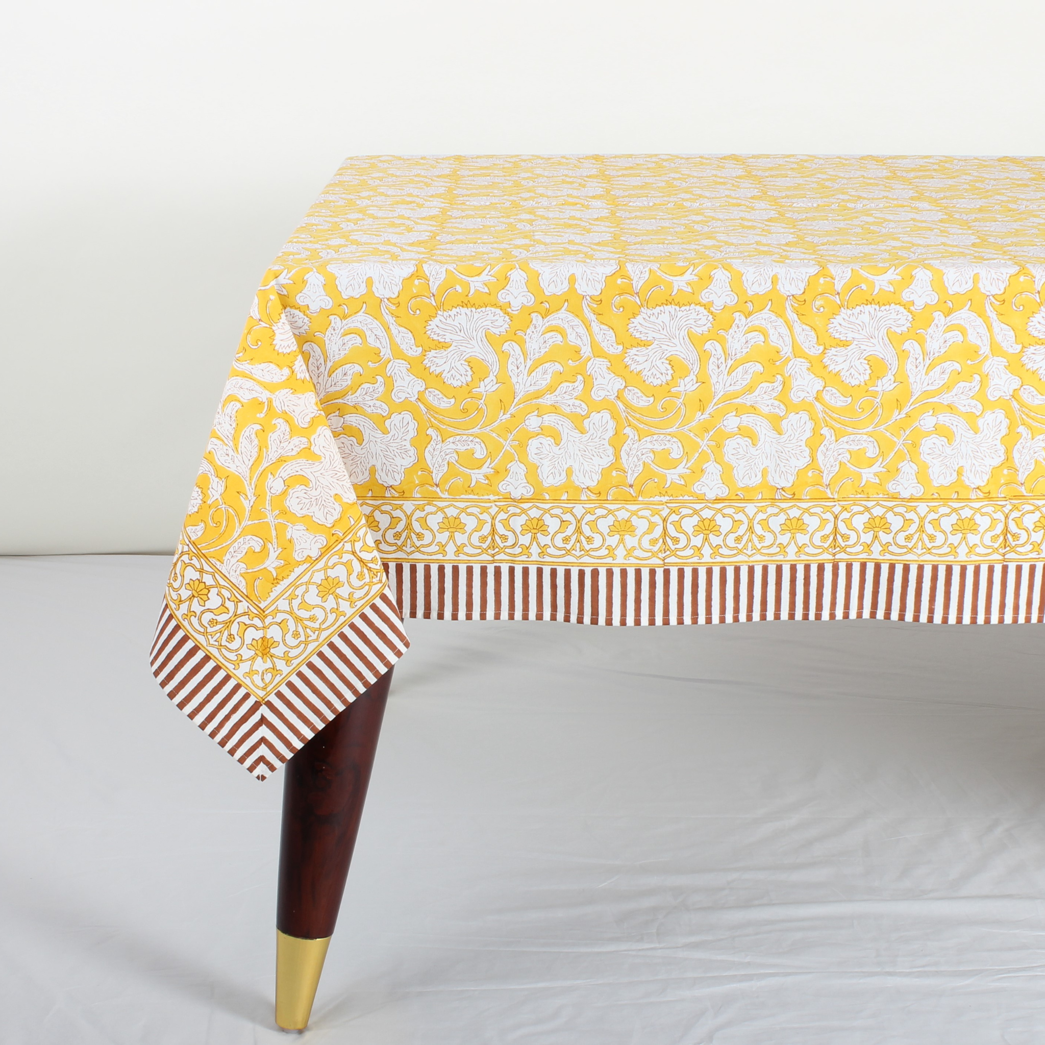 Yellow and white patterned tablecloth on a table with a white background